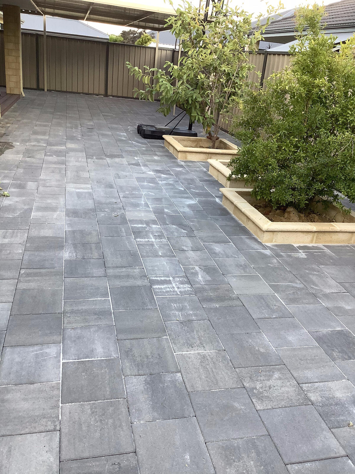 Paved patio bordered by limestone garden beds