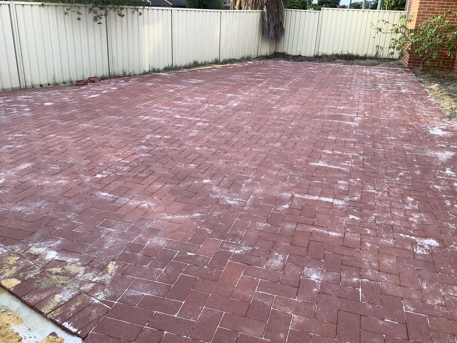 Red brick paving across a backyard
