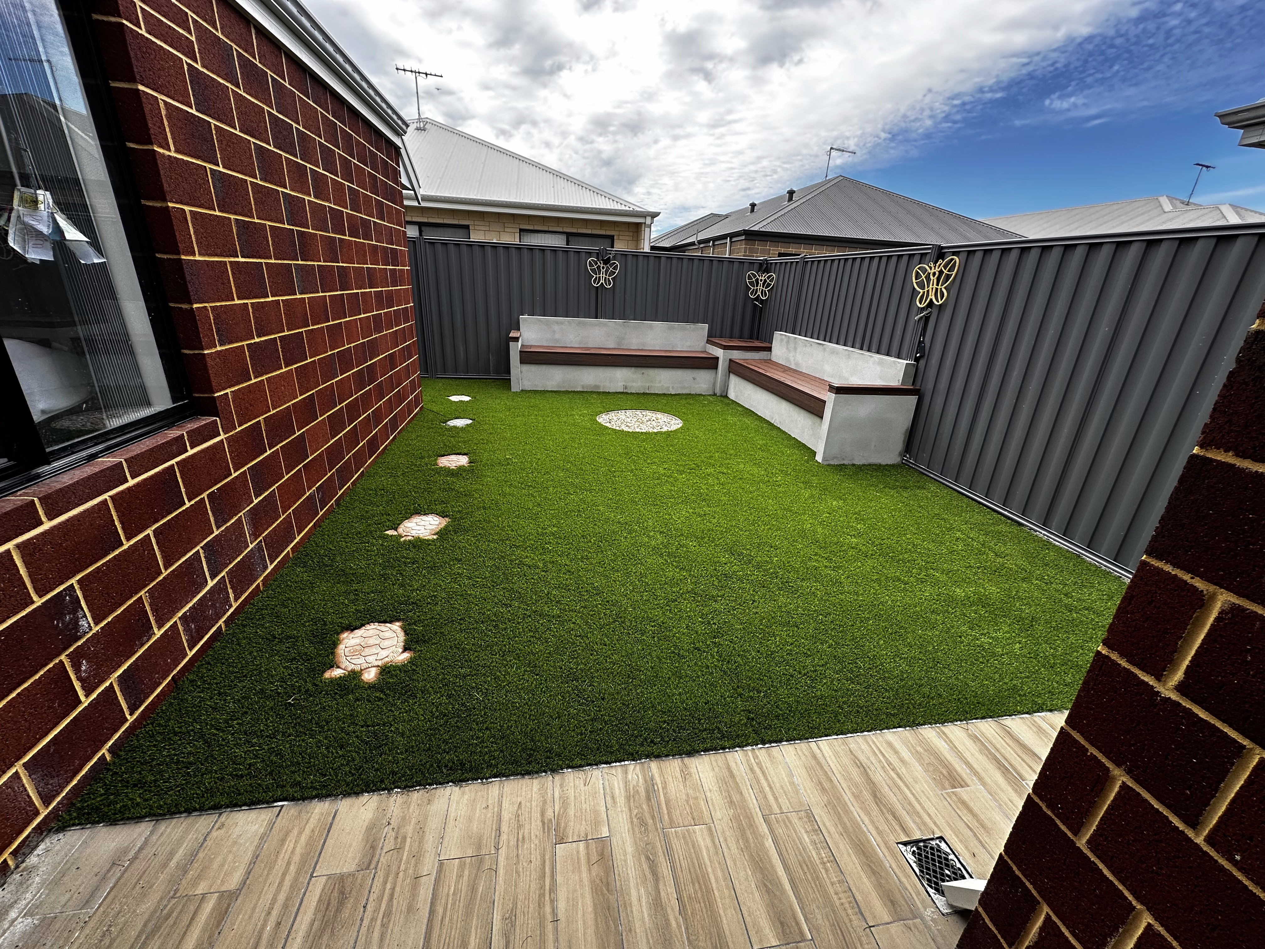 Rendered bench seating built into a backyard with artificial turf