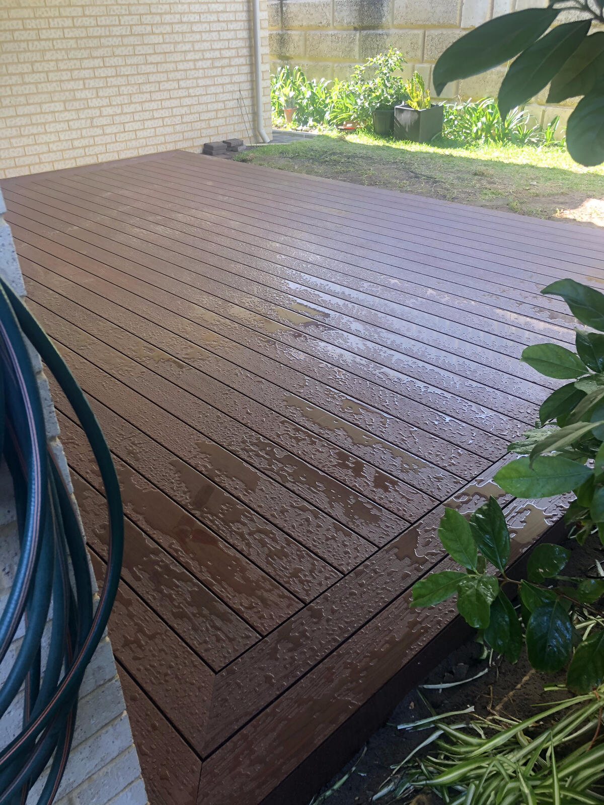 Composite decking running alongside a garden bed