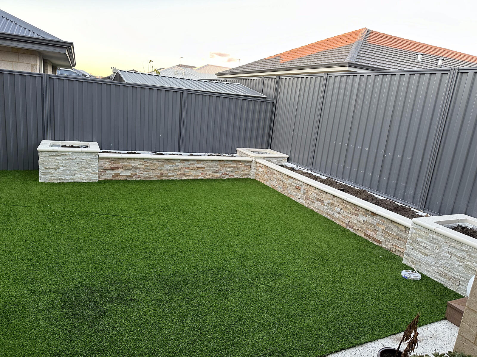 Artificial turf bordered by a stacked stone garden wall